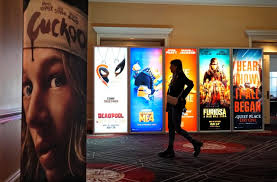 A girl walking with movie posters in the background